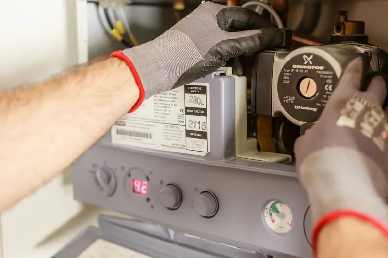 Gloved hands servicing a heating unit