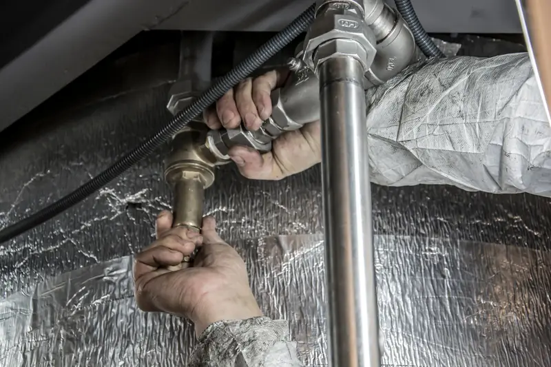 Plumber fitting copper pipes under a floor